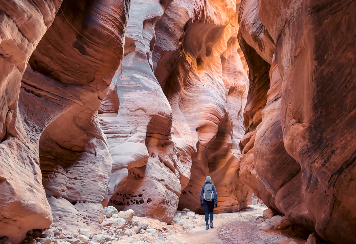 バックスキン・ガルチ(Buckskin Gulch)A female hiker walks through the majestic Buckskin Gulch, a deep and narrow slot canyon on the Arizona / Utah border. The towering sandstone walls, sculpted by erosion, create a sense of awe - USA